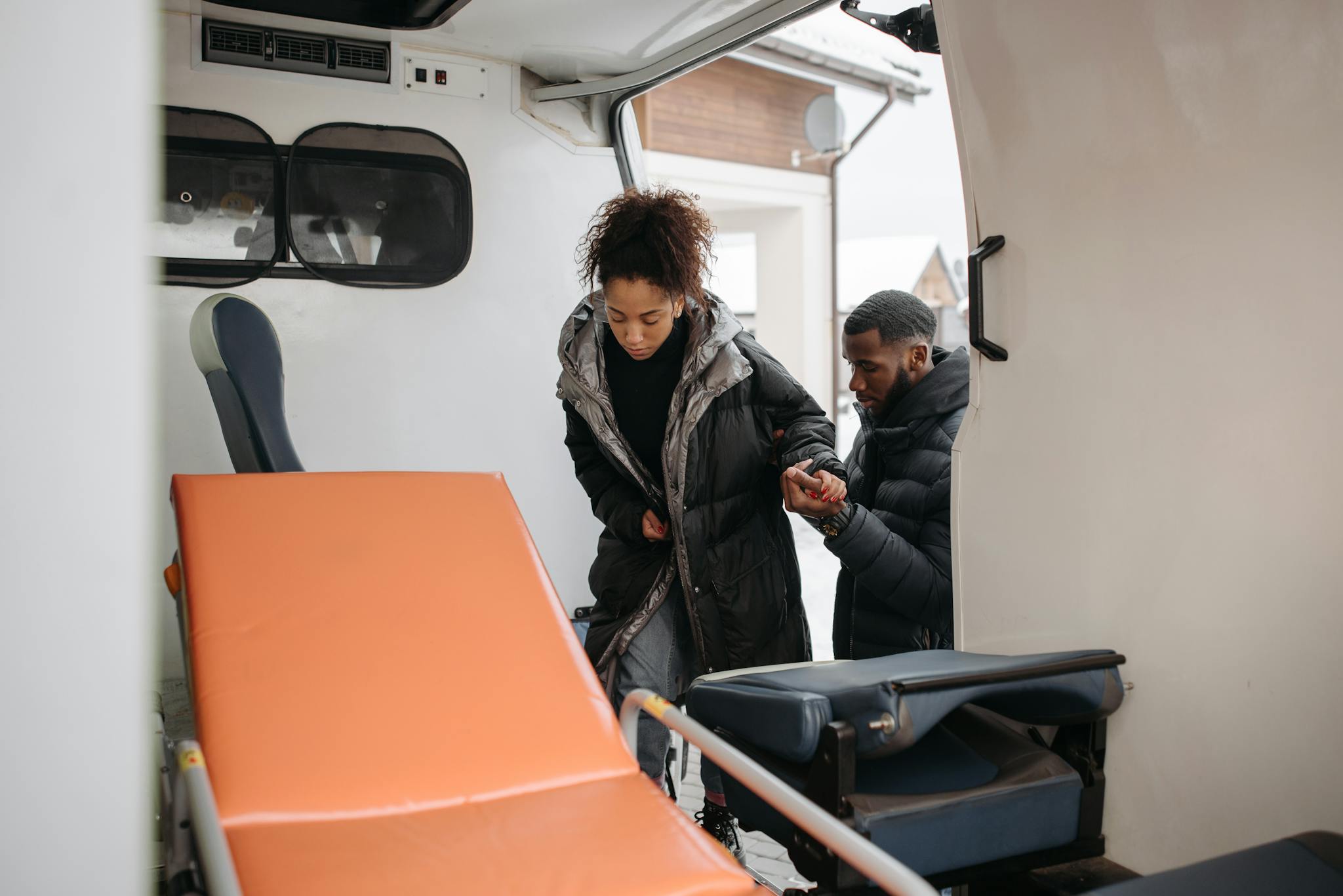 A compassionate scene of helping a person into an ambulance, highlighting emergency care.